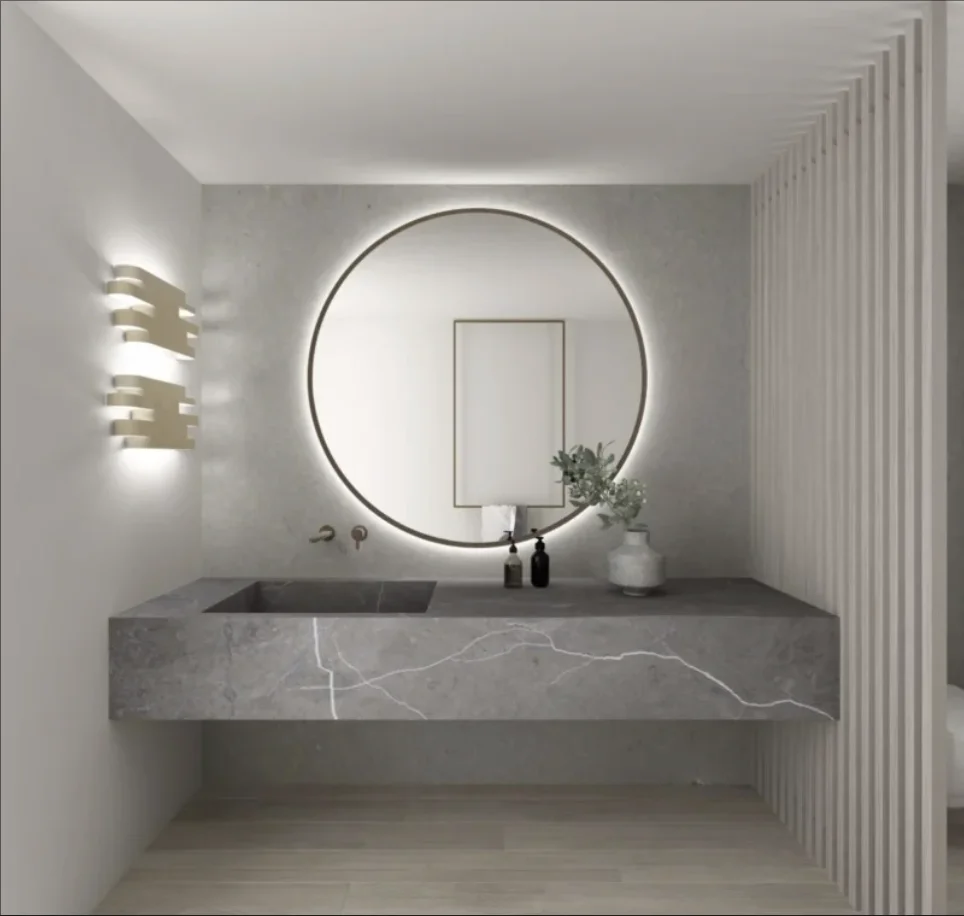 Gray marble bathroom vanity countertop with integrated sinks and backlit circular mirror