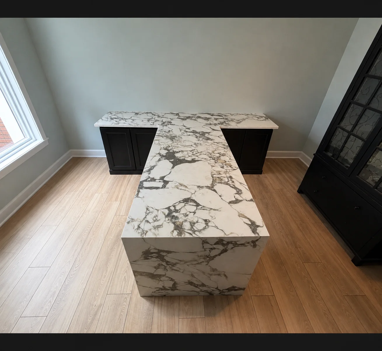White marble countertop with gray veining on kitchen island with black cabinet base