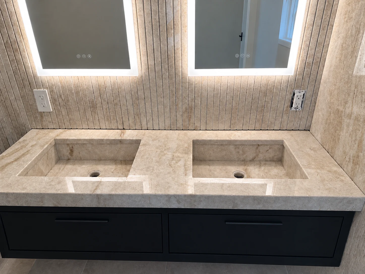 Marble dual vanity countertop with integrated sinks and waterfall edge detail