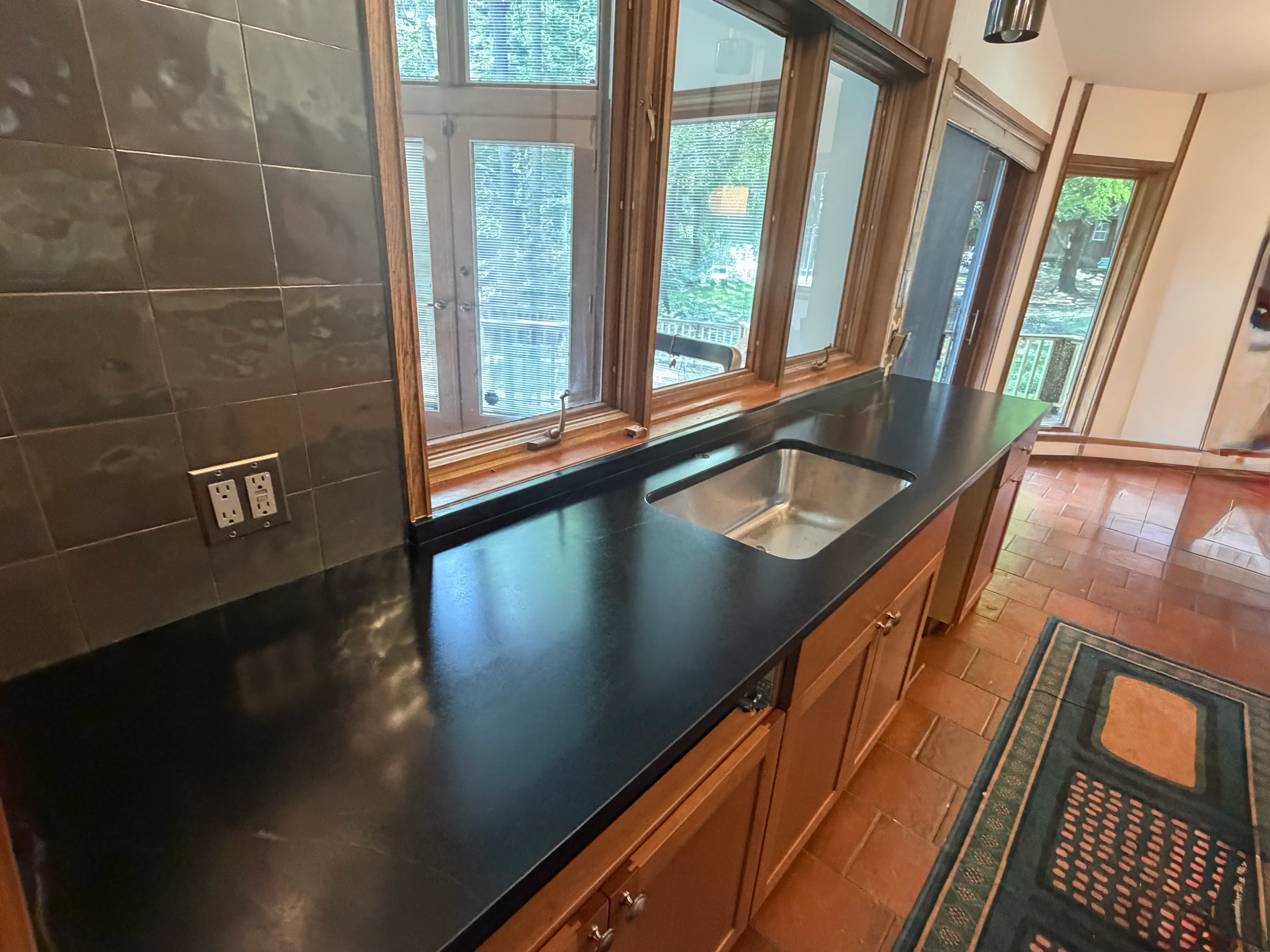 Black quartz countertop with undermount sink and gray subway tile backsplash in kitchen