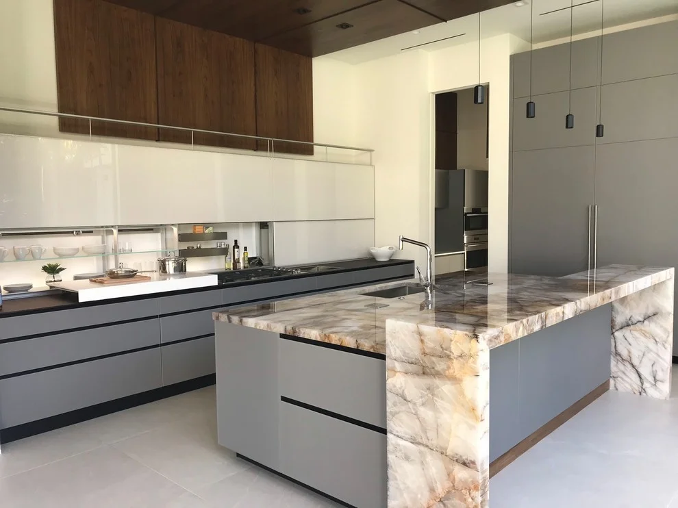 Modern kitchen with marble waterfall island countertop and gray cabinetry
