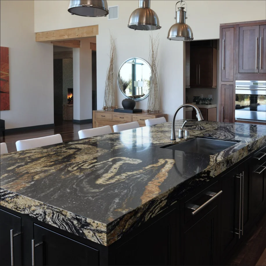 Newly installed stone countertop in a residential kitchen in Clarence, NY, with clean edge profiles and a flush sink cutout set over white cabinetry. The finished surface reflects natural light from a nearby window in a single-family home.